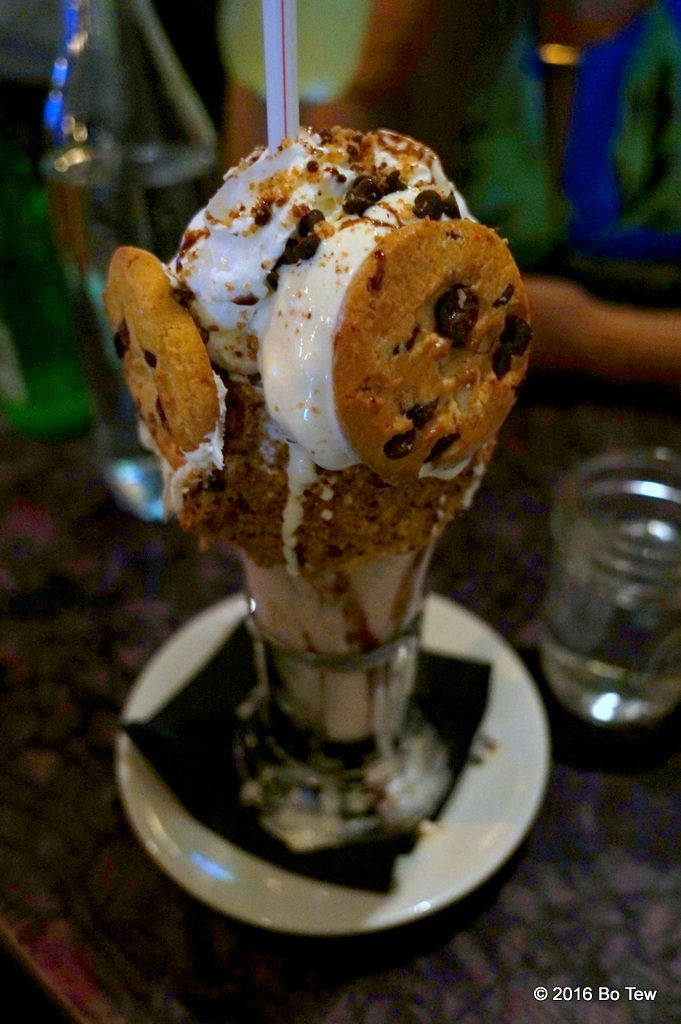 The Cookie Shake: Vanilla Cookie shake with vanilla frosted rim with cookie crumbles, topped with a 'Cookiewich' crumbled cookies, chocolate chips, whipped cream & chocolate drizzle. 